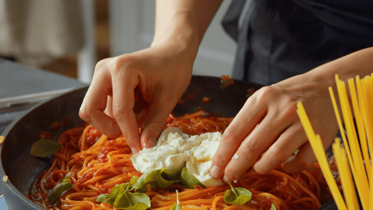 Sartén con espaguetis en una olla con burrata
