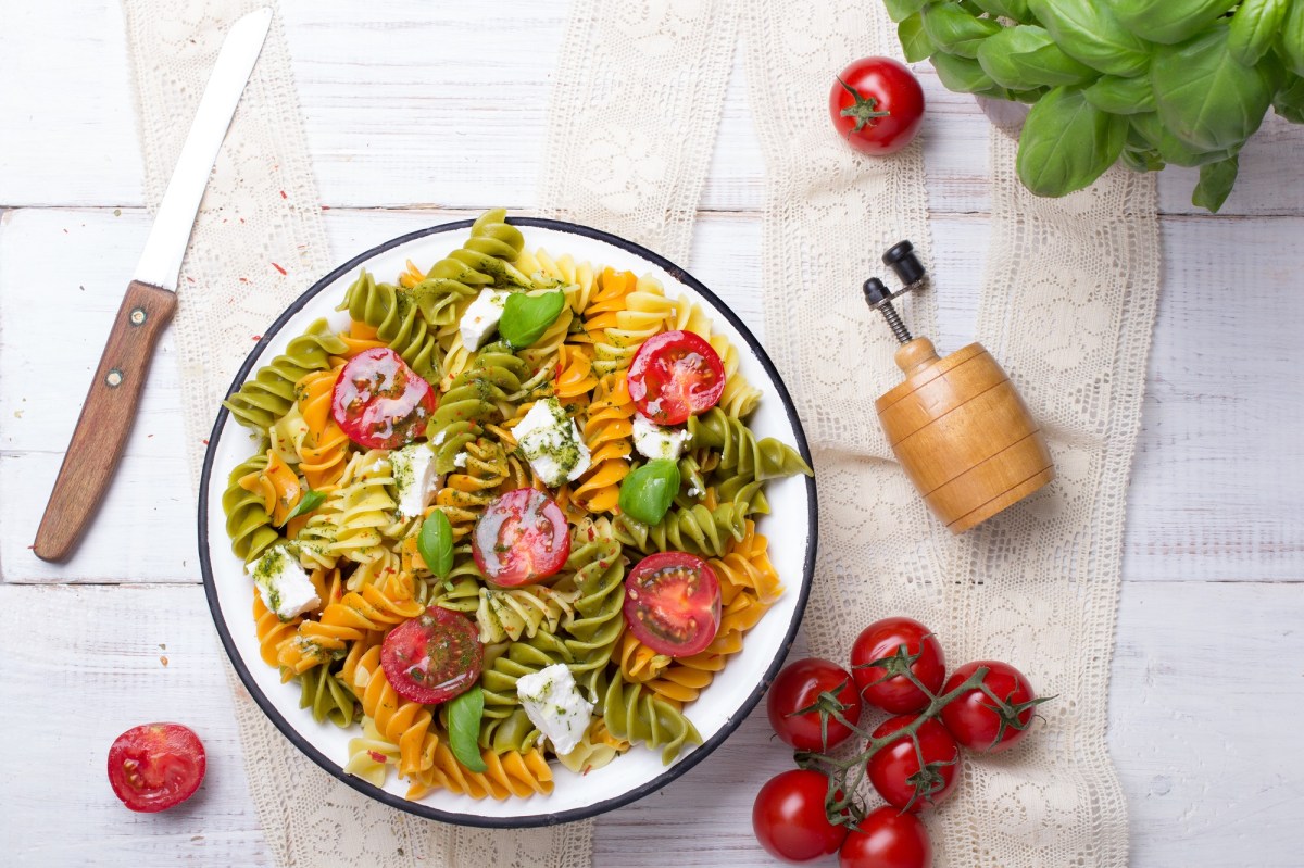 Tazón con ensalada de pasta mediterránea con pesto.
