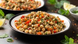 Un tazón de ensalada tailandesa de quinoa con garbanzos y verduras.