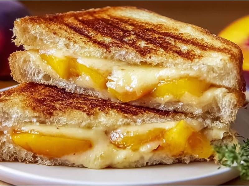 Plato con dos sándwiches de queso a la parrilla con melocotón