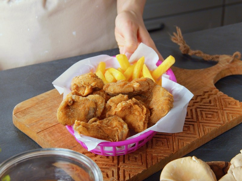 Setas ostra empanizadas con papas fritas en un bol.